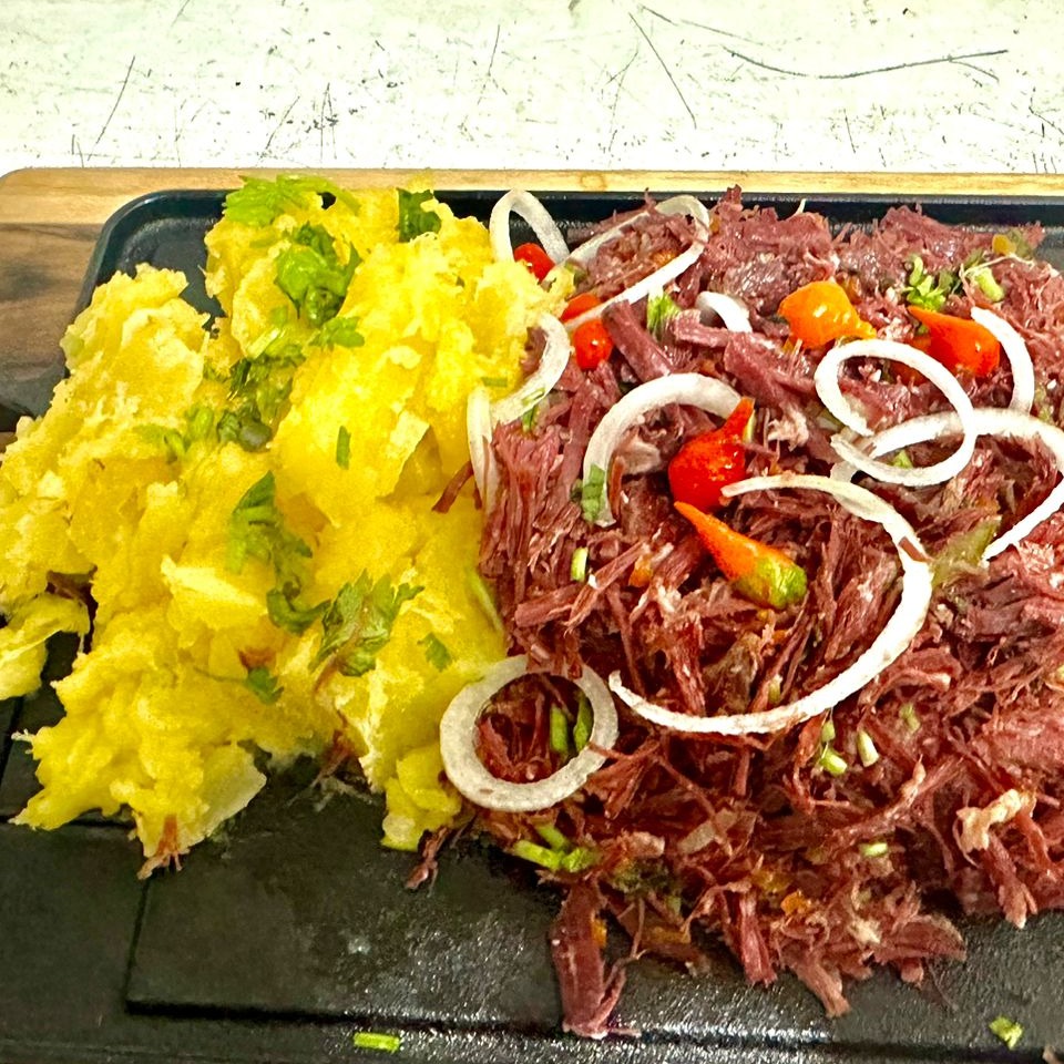 Carne seca desfiada com cebola roxa e aipim na manteiga de garrafa.