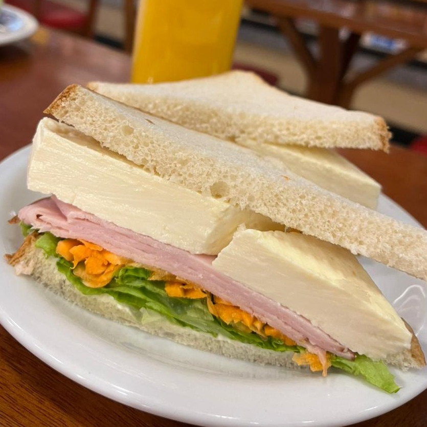 Lanche no Pão de forma recheado de peito de peru, queijo Minas, cenoura ralada, alface e tomate 